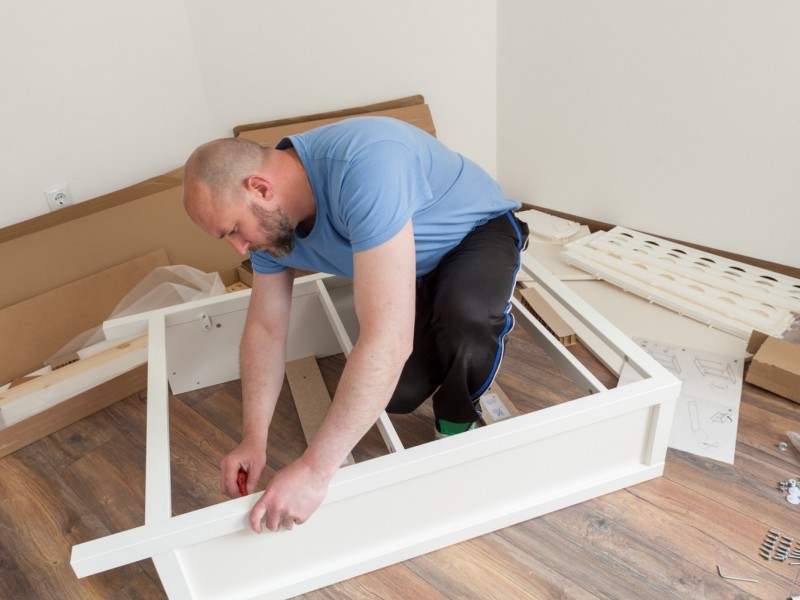 A mover disassembling a cabinet to make it easier to move